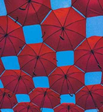 Rote Regenschirme vor blauem Himmel