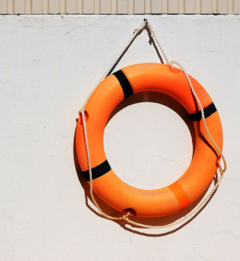 oranger Rettungsring an weißer Wand