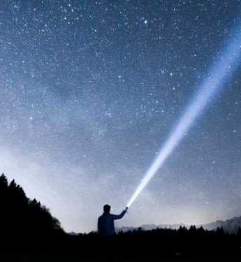 Mann mit Taschenlampe in der Natur