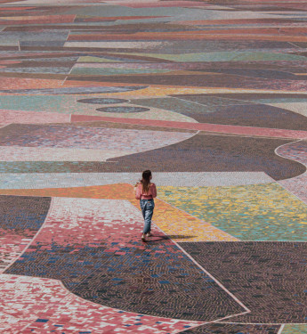 Frau läuft über interessant gepflasterten Platz