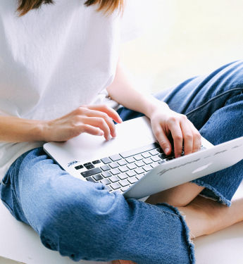 Frau im Schneidersitz mit Laptop