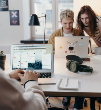 Junge Menschen arbeiten gemeinsam in einem Team an Laptops