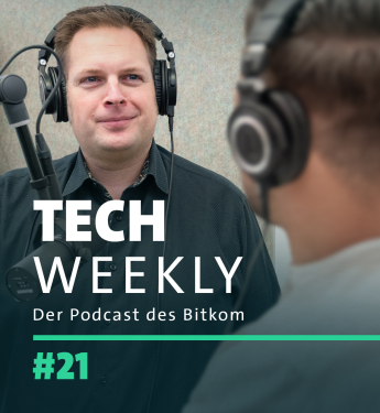 Ein Werbebanner für die 21. Episode von "Tech Weekly", dem Podcast des Bitkom. Im Vordergrund sieht man einen Mann in einem dunklen Hemd, der Kopfhörer trägt und vor einem Mikrofon spricht, was darauf hindeutet, dass er ein Moderator oder Interviewer sein könnte. Im Hintergrund ist eine unscharfe Figur, vermutlich ein Gast oder Co-Moderator, teilweise sichtbar. Die Farbpalette des Banners ist gedämpft mit grauen und blauen Tönen und einem markanten türkisfarbenen Streifen am unteren Rand, der zum Design bei