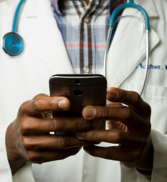 Ein Arzt mit Handy in der Hand als Sinnbild für das Get Started Health Network zum Thema DiGa