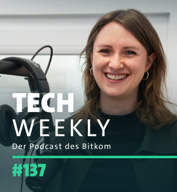 Lächelnde Frau mit langen, braunen Haaren, schwarzem Oberteil und Kopfhörern vor grauer Wand. Text: "TECH WEEKLY Der Podcast des Bitkom #137".