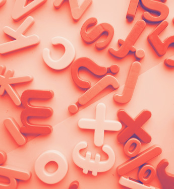 Bunte Buchstaben und Zeichen in Rot und Weiß auf einer flachen Oberfläche, verschiedene Größen und Formen.