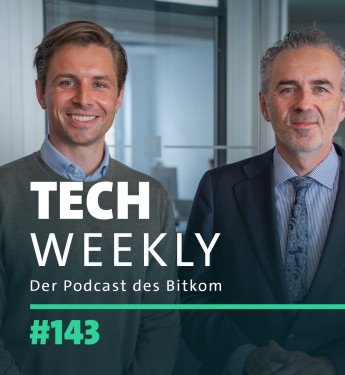 Zwei Personen stehen nebeneinander. Links: hellbraune Haare, grauer Pullover, blaues Hemd. Rechts: graue Haare, dunkler Anzug, hellblaue Krawatte. Hintergrund: helle Wände, Fenster. Text: "TECH WEEKLY", "