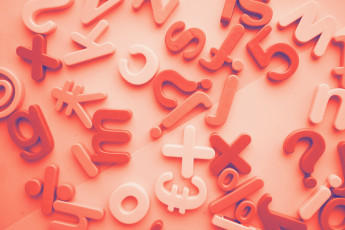 Bunte Buchstaben und Zeichen in Rot und Weiß auf einer flachen Oberfläche, verschiedene Größen und Formen.