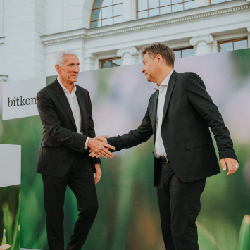 Ralf Wintergerst und Robert Habeck stehen auf der Bühne und geben sich einen Handschlag.