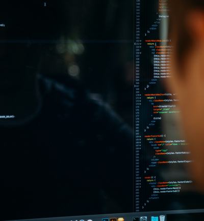 Man sitzt vor Computer und schaut sich Quellcode an