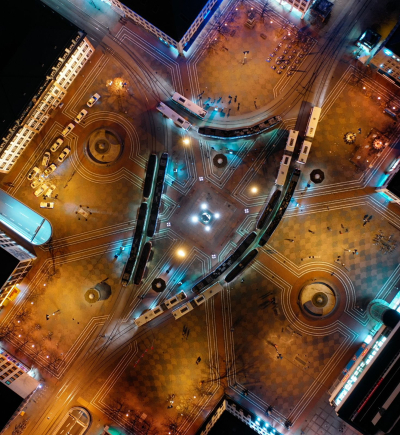 Straßenkomplex von oben betrachtet bei Nacht mit 4 Zufahrtsmöglichkeiten (Sinnbild für Themenkomplexe einer Smart City.