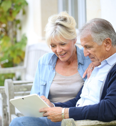 Rentnerpärchen guckt auf Terrasse gemeinsam auf Tablet