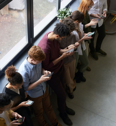 aufs Smartphone guckende Menschen am Fenster