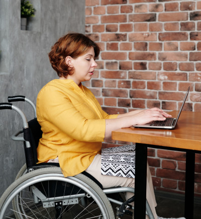 Frau im Rollstuhl am Computer