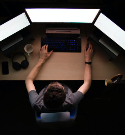 Programmierer mit drei Bildschirmen