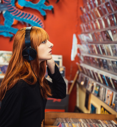 Frau hört im Plattenladen Musik
