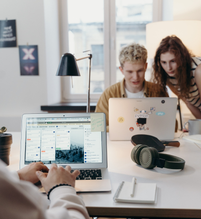 Junge Menschen arbeiten gemeinsam in einem Team an Laptops