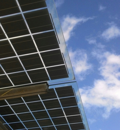 Ein abstraktes Bild eines Solarpanels vor blauem Hintergrund. Das Bild ist ein Sinnbild für die Digitalisierung der Energiewirtschaft und erneuerbare Energien.