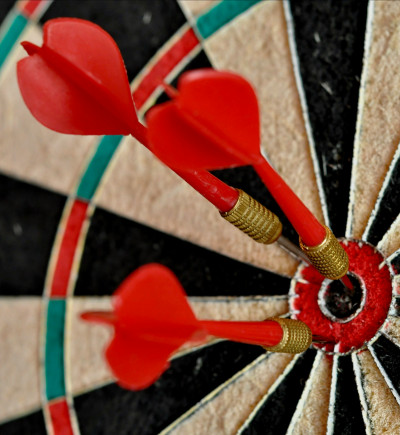 Dartscheibe mit mehreren Pfeilen in der Mitte. 