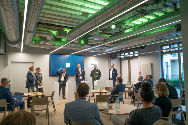 Agrarpolitisches Frühstück - Impressionen: In einem modernen Bitkom-Veranstaltungsraum mit sichtbaren Lüftungsrohren und grüner Beleuchtung an der Decke findet eine Diskussionsrunde statt.