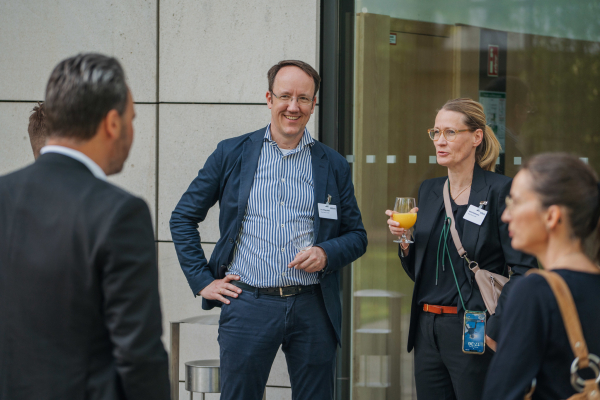 Eine Gruppe von vier Personen unterhält sich im Außenbereich des Bitkom Forum Recht 2025.