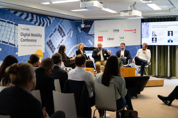 Panel discussion at the Digital Mobility Conference 2026 with audience and partner logos in a modern setting.